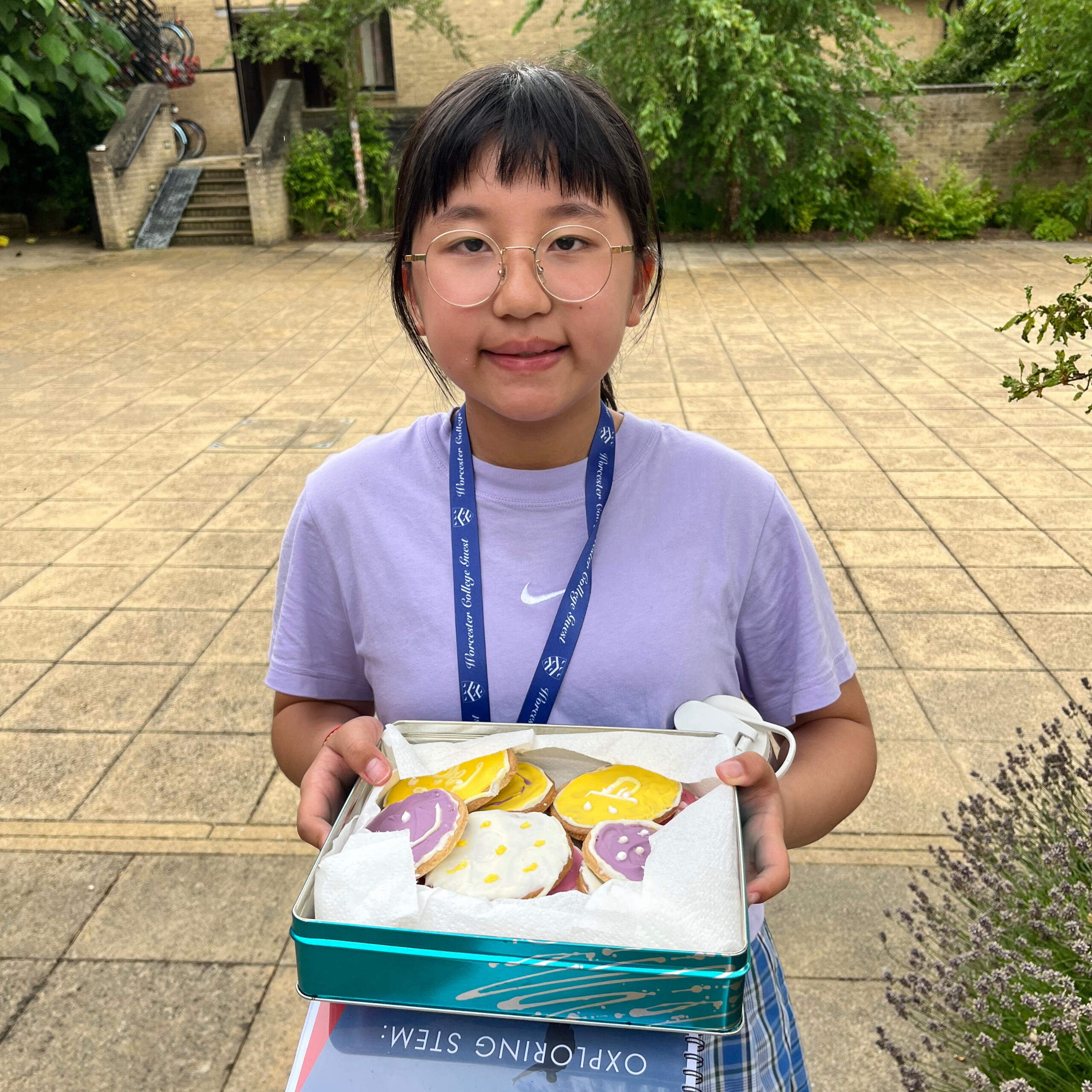 A girl holding a tin box full of home made biscuits.